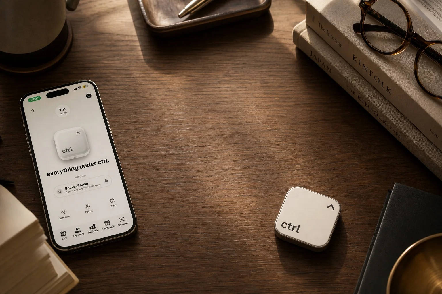 An iPhone with the ctrl app next to the ctrl key on a warm wooden desk