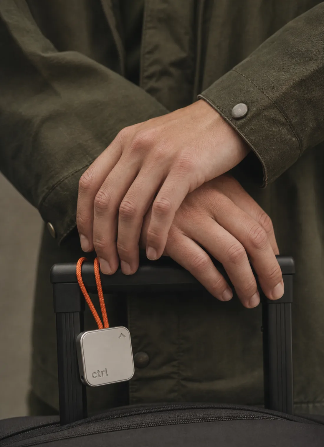 A person with a suitcase, the ctrl key on its strap on the handle